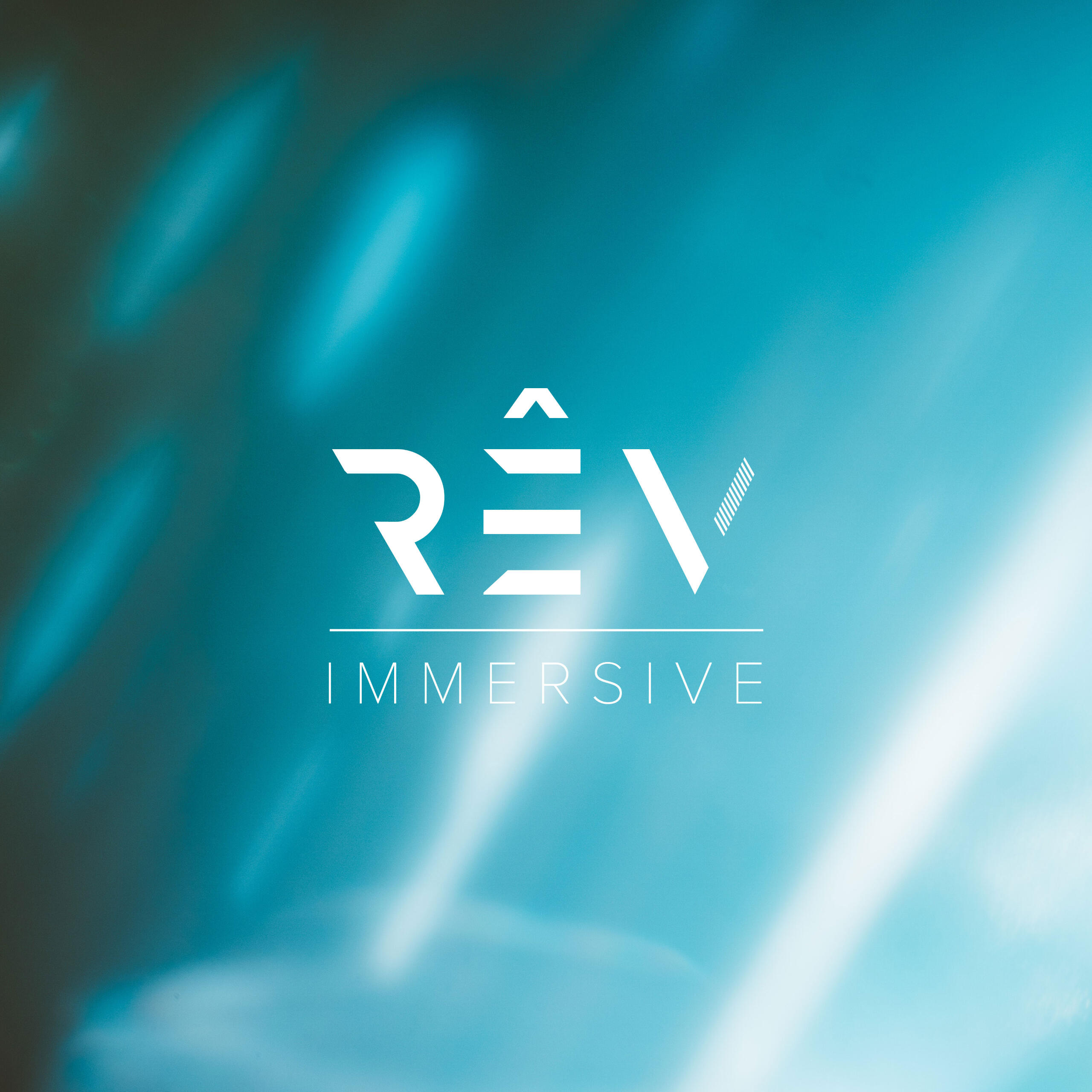 The RÊV IMMERSIVE logo over a blue background.